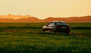 Preview wallpaper car, black, field, sunset