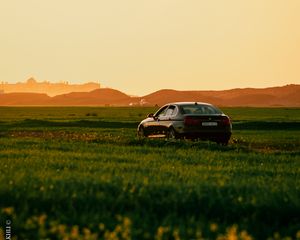 Preview wallpaper car, black, field, sunset