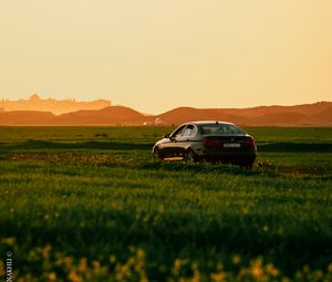 Preview wallpaper car, black, field, sunset