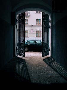 Preview wallpaper car, black, gate, building, street