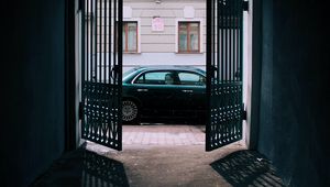 Preview wallpaper car, black, gate, building, street