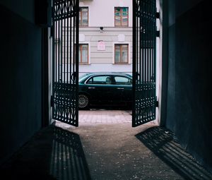 Preview wallpaper car, black, gate, building, street
