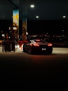 Preview wallpaper car, black, lights, back view, gas station