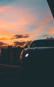 Preview wallpaper car, dark, city, headlight, light, front view