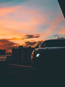 Preview wallpaper car, dark, city, headlight, light, front view