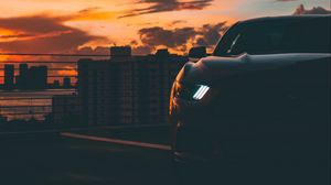 Preview wallpaper car, dark, city, headlight, light, front view