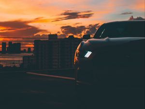 Preview wallpaper car, dark, city, headlight, light, front view