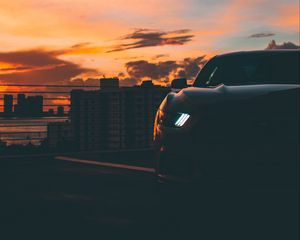 Preview wallpaper car, dark, city, headlight, light, front view