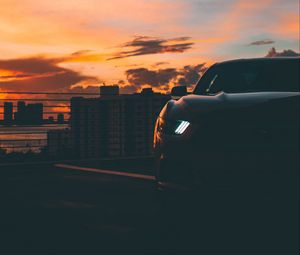 Preview wallpaper car, dark, city, headlight, light, front view