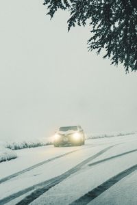 Preview wallpaper car, lights, snow, fog, branches, winter