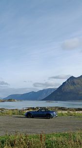 Preview wallpaper car, mountains, rocks, coast, sky