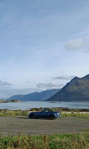 Preview wallpaper car, mountains, rocks, coast, sky