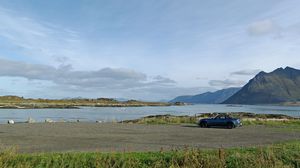 Preview wallpaper car, mountains, rocks, coast, sky