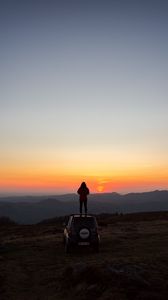 Preview wallpaper car, person, sunset, mountains, nature