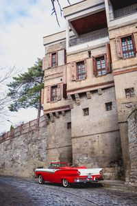 Preview wallpaper car, red, retro, buildings, road