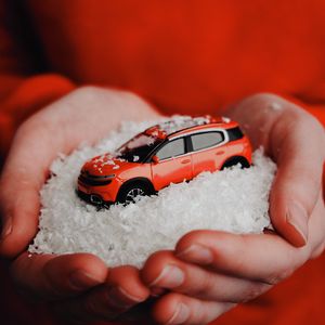 Preview wallpaper car, red, snow, toy, hands
