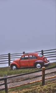 Preview wallpaper car, retro, red, hillock, fence