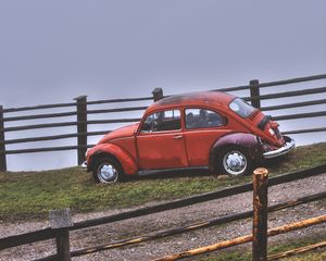 Preview wallpaper car, retro, red, hillock, fence