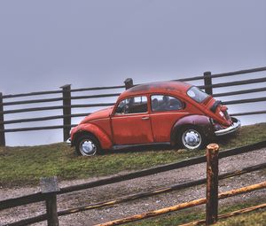 Preview wallpaper car, retro, red, hillock, fence