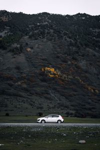 Preview wallpaper car, side view, mountains, slope, road