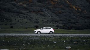 Preview wallpaper car, side view, mountains, slope, road