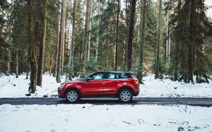 Preview wallpaper car, side view, red, road, forest, snowy