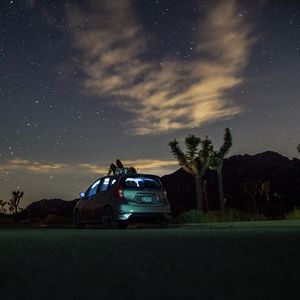 Preview wallpaper car, starry sky, man, loneliness, palm trees, solitude