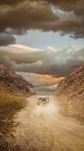 Preview wallpaper car, suv, road, dust, sky