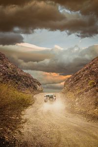 Preview wallpaper car, suv, road, dust, sky