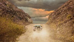 Preview wallpaper car, suv, road, dust, sky