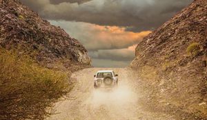 Preview wallpaper car, suv, road, dust, sky