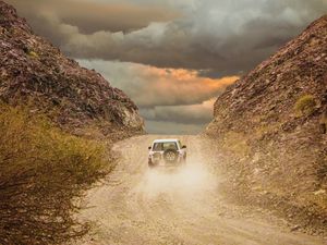 Preview wallpaper car, suv, road, dust, sky