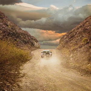 Preview wallpaper car, suv, road, dust, sky