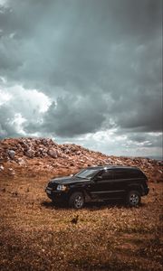 Preview wallpaper car, suv, side view, stones, sky