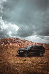 Preview wallpaper car, suv, side view, stones, sky