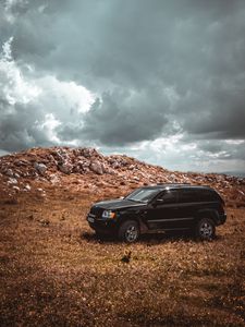 Preview wallpaper car, suv, side view, stones, sky