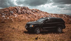 Preview wallpaper car, suv, side view, stones, sky