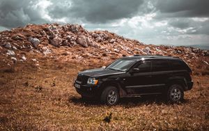 Preview wallpaper car, suv, side view, stones, sky