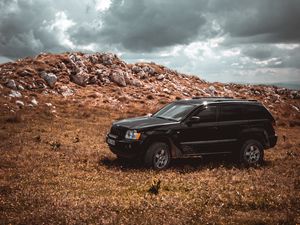 Preview wallpaper car, suv, side view, stones, sky