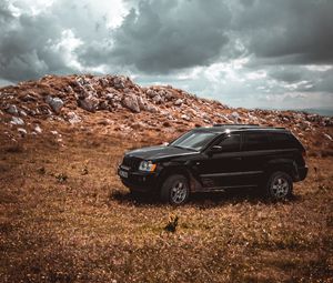 Preview wallpaper car, suv, side view, stones, sky