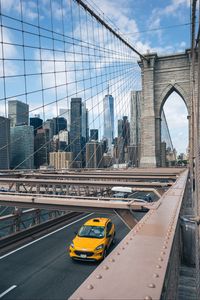 Preview wallpaper car, yellow, bridge, city, buildings