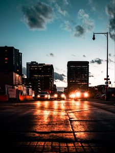 Preview wallpaper cars, headlights, light, road, buildings, twilight