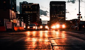 Preview wallpaper cars, headlights, light, road, buildings, twilight