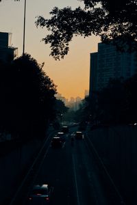 Preview wallpaper cars, road, sunset, architecture, branches, movement