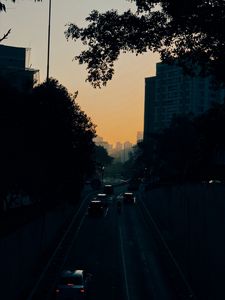 Preview wallpaper cars, road, sunset, architecture, branches, movement