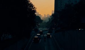 Preview wallpaper cars, road, sunset, architecture, branches, movement