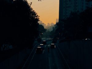 Preview wallpaper cars, road, sunset, architecture, branches, movement