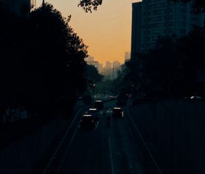 Preview wallpaper cars, road, sunset, architecture, branches, movement