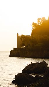 Preview wallpaper castle, coast, cliffs, sea, sunset