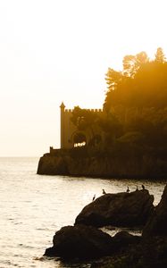 Preview wallpaper castle, coast, cliffs, sea, sunset